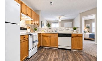 Aiken apartment for rent - A kitchen with wooden cabinets and white appliances.
