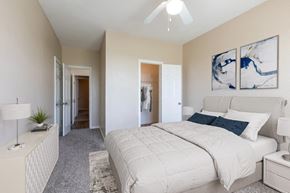 Slidell apartment for rent - a bedroom with a white bed and a ceiling fan