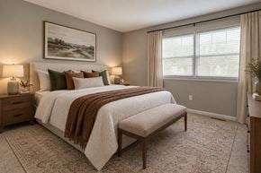 Glen Burnie townhouse for rent - A bedroom with a large bed and a painting on the wall.