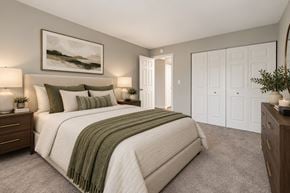 Woodridge apartment for rent - A bedroom with a large bed and a painting on the wall.