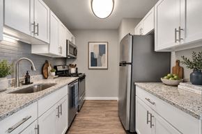 Woodridge apartment for rent - A kitchen with white cabinets and a grey refrigerator.