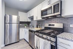 Woodridge apartment for rent - a kitchen with stainless steel appliances and white cabinets