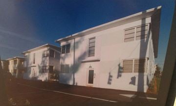 Miami Beach apartment for rent - A white building with a black door and windows.