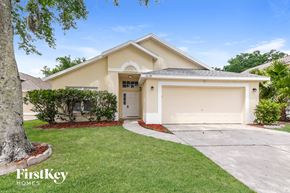 Kissimmee house for rent - a beige house with a driveway and a garage door