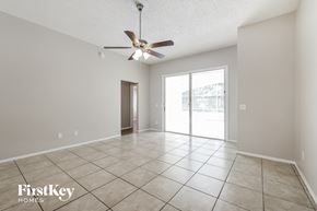 Kissimmee house for rent - a spacious living room with tile flooring and a ceiling fan
