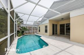 Kissimmee house for rent - a swimming pool in the backyard of a house with a glass roof