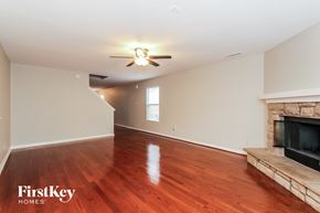 Charlotte house for rent - A spacious living room with wood flooring and a fireplace.