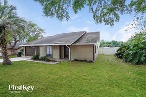 Orlando house for rent - a small brown house with a yard and a palm tree