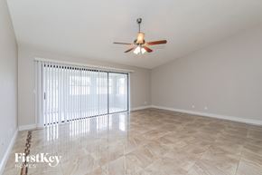Orlando house for rent - a living room with a large window and a ceiling fan