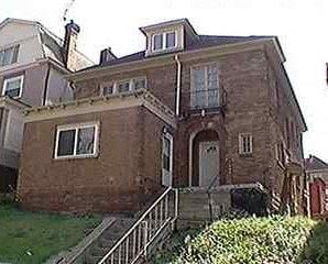 Munhall apartment for rent - A brown brick house with a white door and a window.