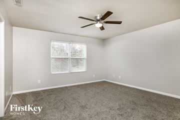 Raleigh house for rent - a living room with carpet and a ceiling fan