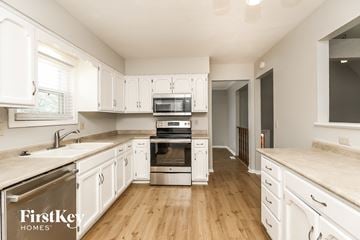 Kansas City house for rent - a kitchen with white cabinets and stainless steel appliances