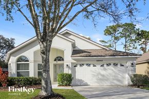 Orlando house for rent - a white house with a white garage door and a tree