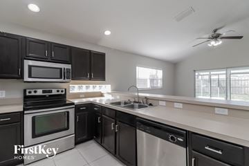 Orlando house for rent - a kitchen with black cabinets and stainless steel appliances