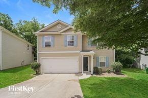 Charlotte house for rent - a tan house with a white garage door