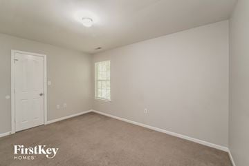 Charlotte house for rent - a bedroom with white walls and carpet and a white door