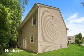 Charlotte house for rent - the side of a house with a green lawn and trees