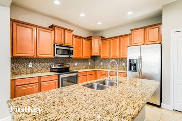 Davenport house for rent - A kitchen with orange cabinets and granite countertops.