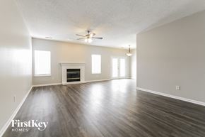 Indianapolis house for rent - an empty living room with a ceiling fan and a fireplace