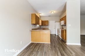 Indianapolis house for rent - a kitchen with wood flooring and wooden cabinets and a white refrigerator