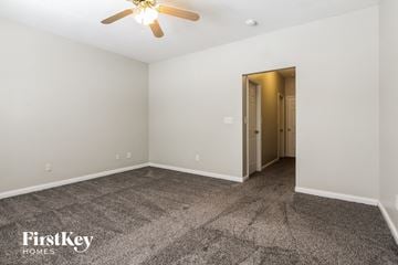 Indianapolis house for rent - a living room with carpet and a ceiling fan