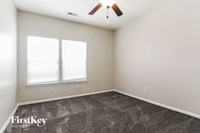 Indianapolis house for rent - a bedroom with carpet and two windows and a ceiling fan