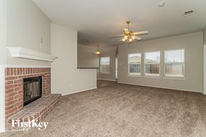 Forney house for rent - a living room with a brick fireplace and a ceiling fan