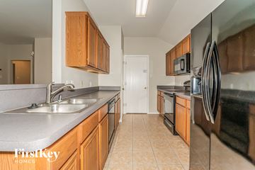Forney house for rent - a kitchen with stainless steel appliances and wooden cabinets