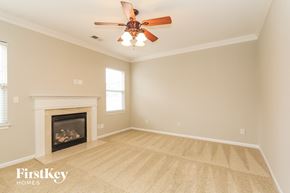 Huntersville house for rent - a living room with a ceiling fan and a fireplace