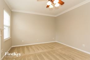 Huntersville house for rent - a empty living room with a ceiling fan and carpet