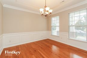 Huntersville house for rent - a dining room with wood floors and two windows and a chandelier
