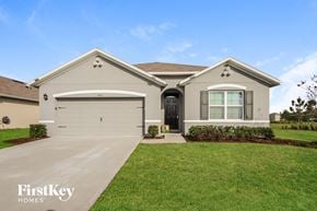 Kissimmee house for rent - A house with a garage and a driveway in front of it.