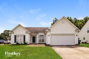 Troutman house for rent - A white house with a brown roof and a garage door.