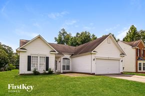 Troutman house for rent - A white house with a brown roof and a garage door is shown.
