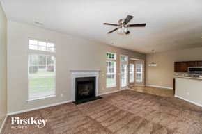 Troutman house for rent - A spacious living room with a fireplace and a ceiling fan.