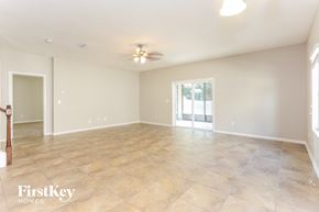 Jacksonville house for rent - A spacious room with a ceiling fan and light fixture, and a tiled floor.