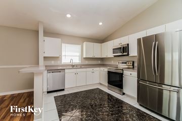 Lake Mary house for rent - a kitchen with white cabinets and stainless steel appliances