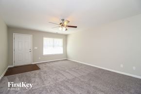 Winston-Salem house for rent - the spacious living room with carpeting and a ceiling fan