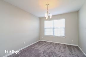 Winston-Salem house for rent - a spacious living room with carpet and a window