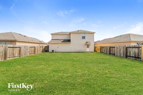 Richmond house for rent - A grassy yard with a house and fence in the background.
