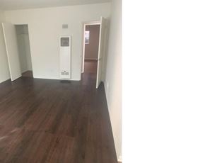 Van Nuys apartment for rent - an empty living room with wood flooring and white walls
