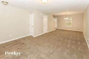 Charlotte house for rent - A spacious room with a carpeted floor and a light fixture on the ceiling.