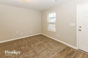 Charlotte house for rent - A room with a carpeted floor and a door on the right side.