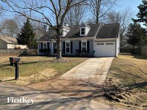 Charlotte house for rent - a white house with a driveway and a tree