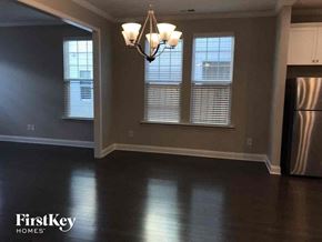 Cramerton house for rent - an empty dining room with a chandelier and three windows