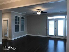 Cramerton house for rent - an empty living room with a ceiling fan and window