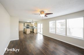 Brownsburg house for rent - A spacious living room with wood flooring and a ceiling fan.