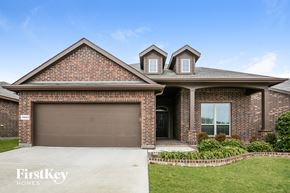 Haslet house for rent - A brick house with a garage door and a window.