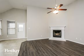 Haslet house for rent - A spacious living room with a fireplace and a ceiling fan.