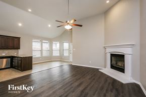 Haslet house for rent - A spacious living room with a fireplace and a ceiling fan.